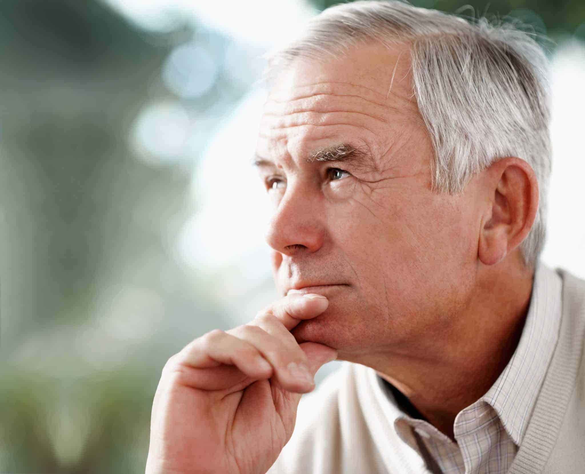 Contemplative senior man with hearing loss looking away