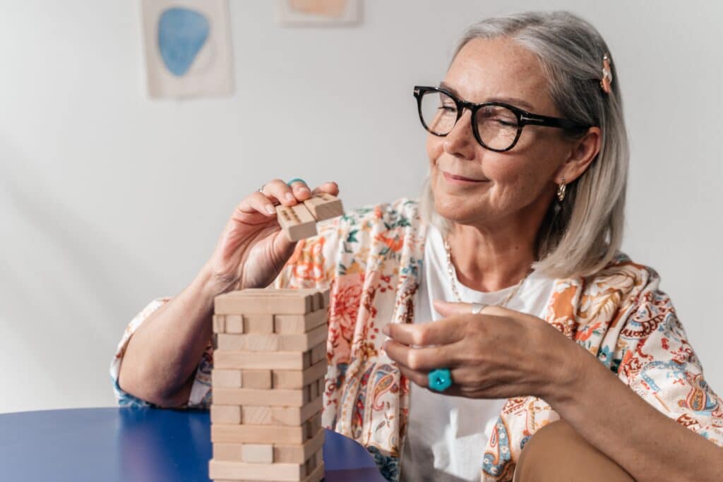 Older woman putting together a puzzle.