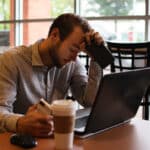 Man experiencing tinnitus at a coffee shop.