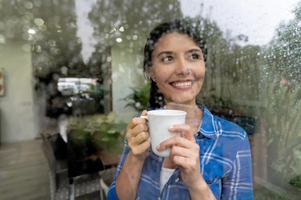 Woman looking out her window at the rainy day