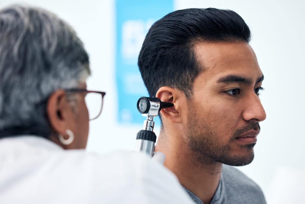 ENT examining a man's ear.