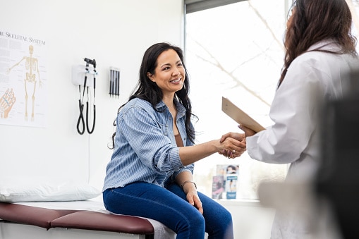 Woman shaking hands with her provider.
